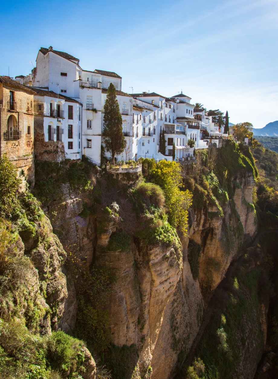 white concrete buildings next to a cliff